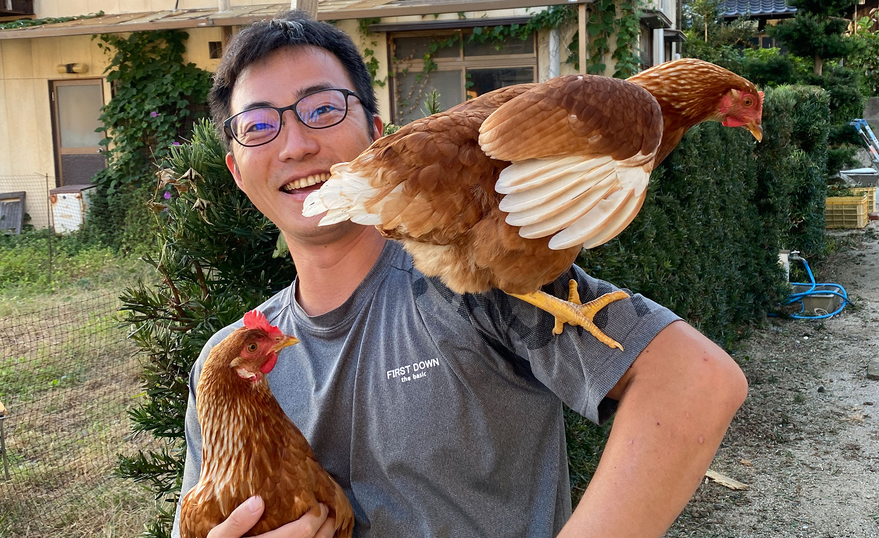 飼育しているニワトリと笑顔の榮さん